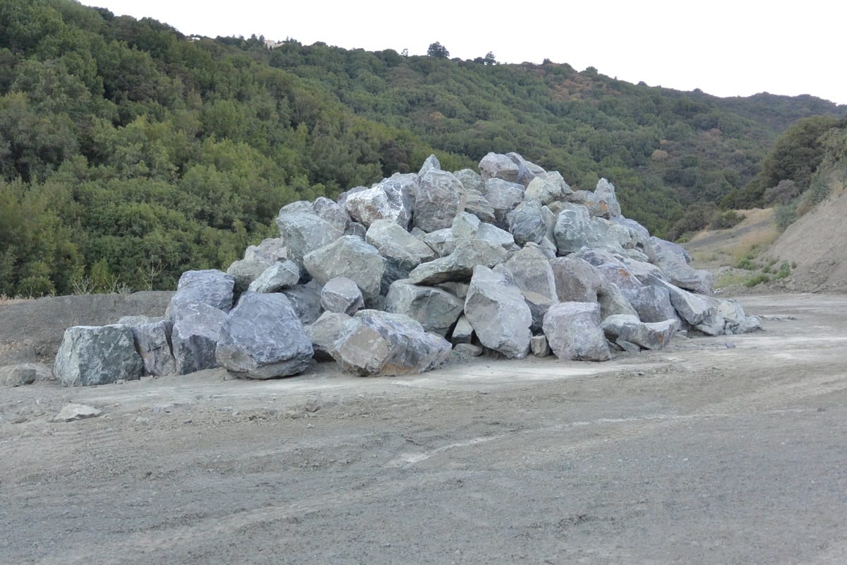 A pile of rocks on the side of a road.